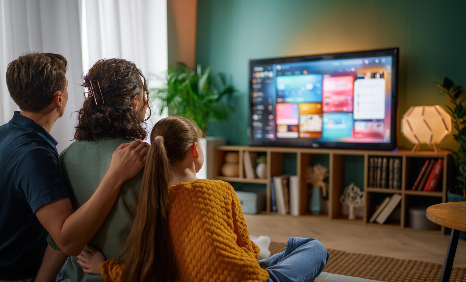Family relaxing in front of a wall-mounted TV with DStv installed by Falcon TV Repairs